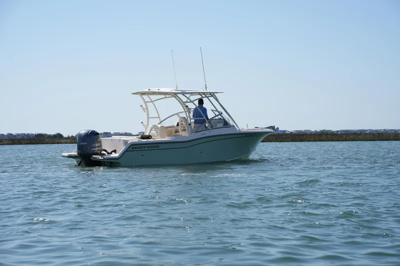 Slide: The Image of 2021 Grady-White Freedom 235 boat cruising on calm water. - 2