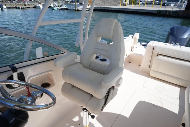 Slide: The Image of 2021 Grady-White Freedom 235 boat interior with captain's chair and steering wheel. - 21