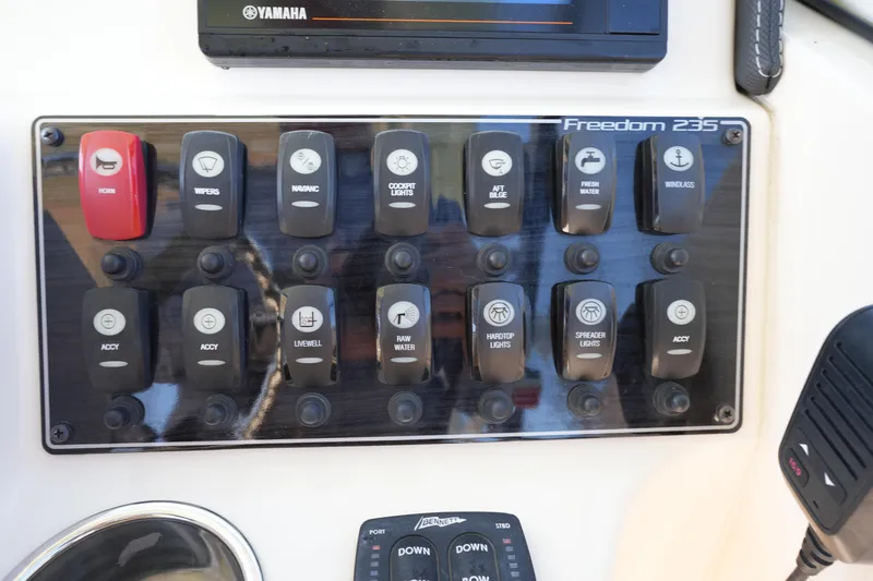 Slide: The Image of Control panel of 2021 Grady-White Freedom 235 boat with labeled switches and buttons. - 25