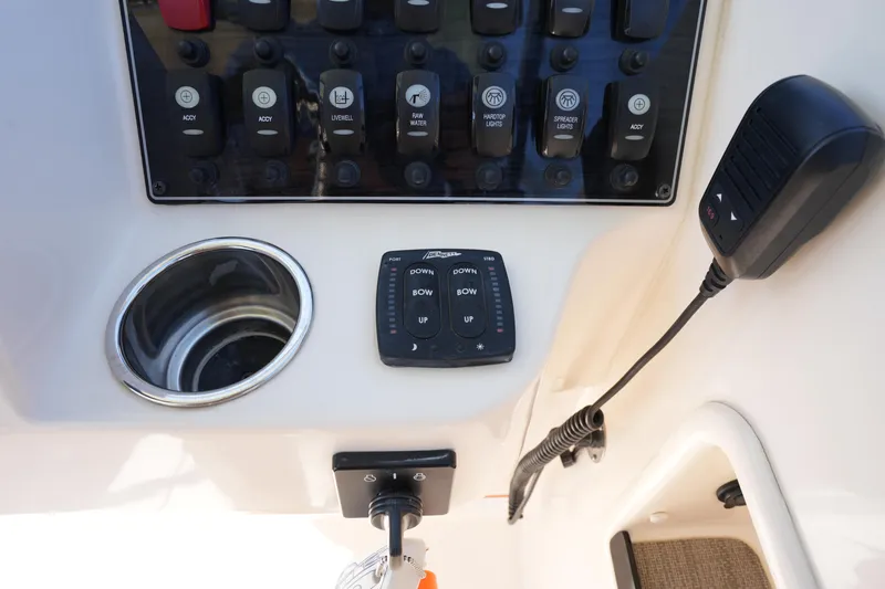 Slide: The Image of Control panel of 2021 Grady-White Freedom 235 boat with switches and microphone. - 26