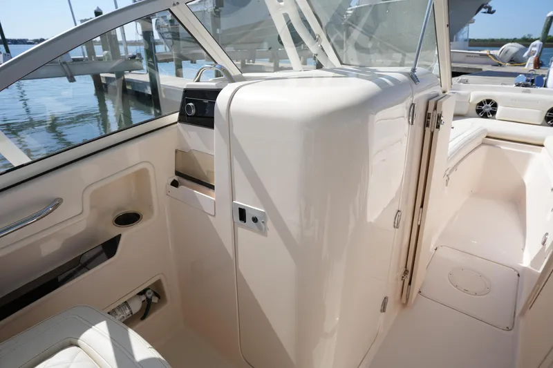 Slide: The Image of 2021 Grady-White Freedom 235 boat interior with seating and storage, docked by the water. - 29