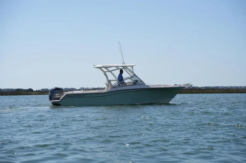 Slide: The Image of 2021 Grady-White Freedom 235 boat cruising on calm waters under clear skies. - 3