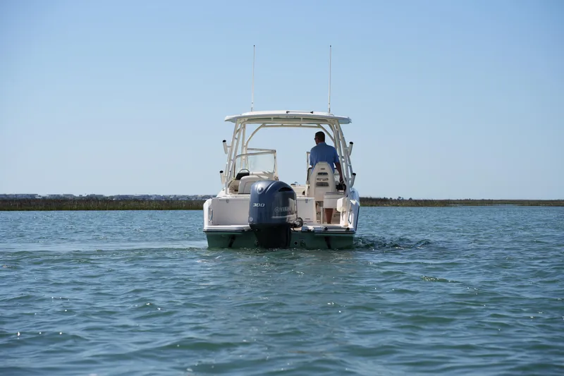 Slide: The Image of 2021 Grady-White Freedom 235 boat cruising on calm water, rear view. - 7