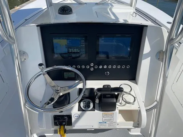 Slide: The Image of 2007 Southport 28 CC boat dashboard with dual screens and steering wheel. - 7