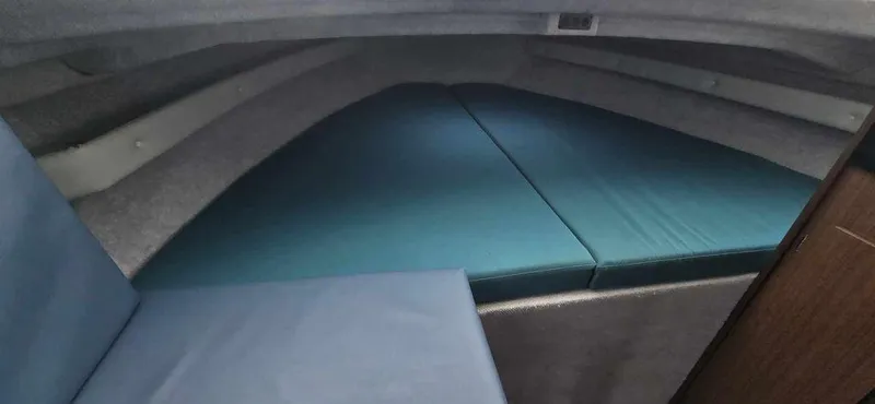 Slide: The Image of 1994 Bayliner 2858 Cierra cabin interior with blue cushions and compact sleeping area. - 6