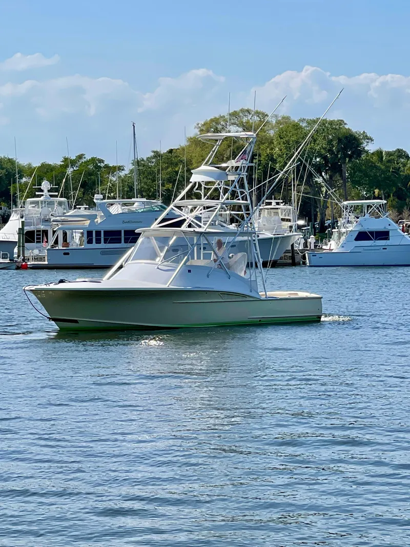 Slide: The Image of 2008 Dixon 34 Custom Carolina Express boat on calm water, surrounded by other yachts. - 0