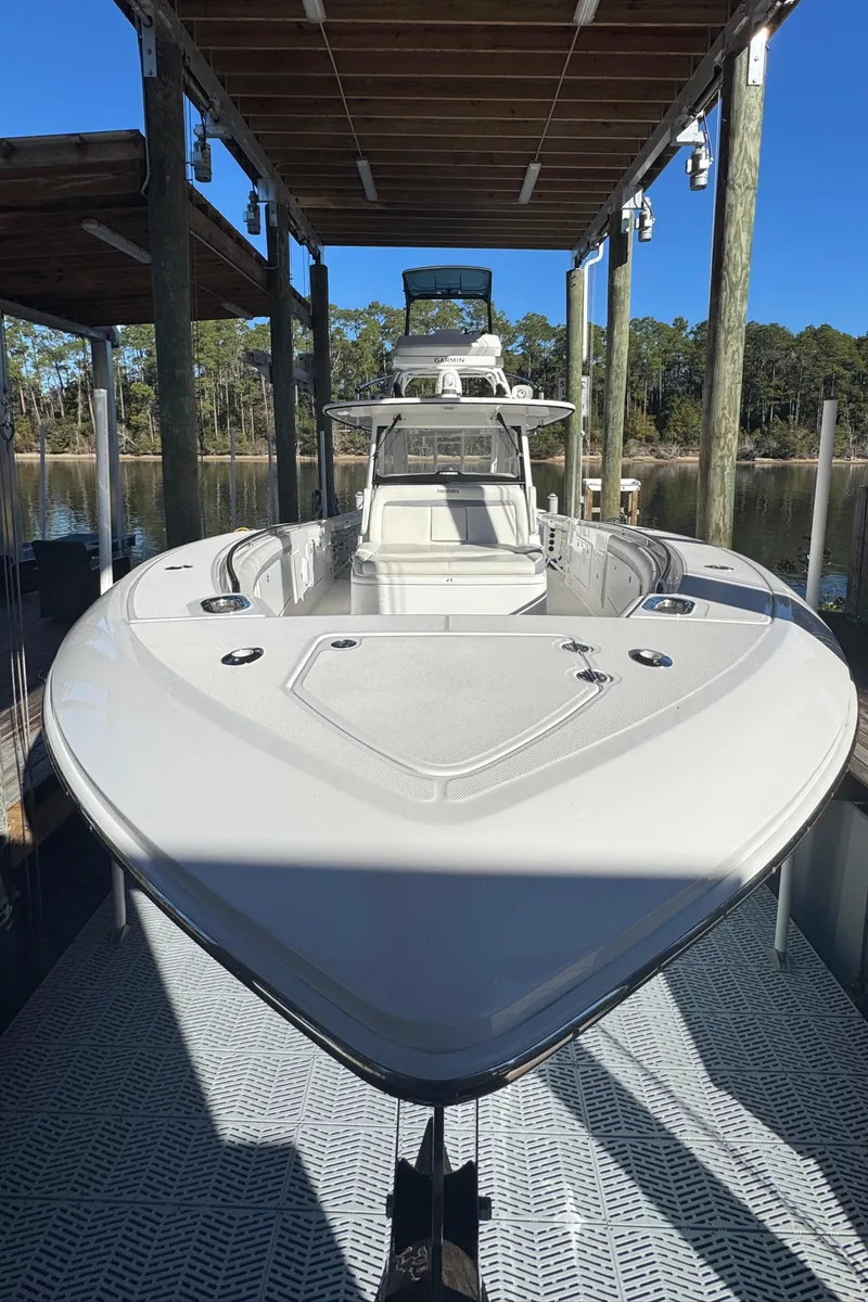 Slide: The Image of 2016 Everglades 435 Center Console boat docked under a wooden canopy. - 14