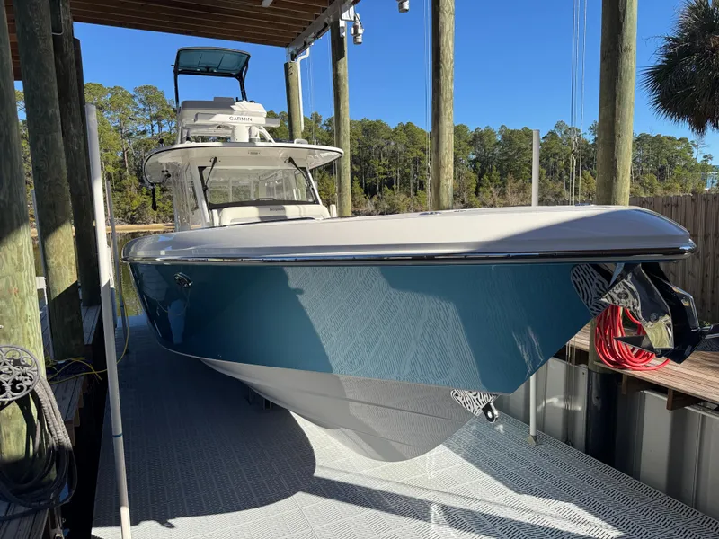 Slide: The Image of 2016 Everglades 435 Center Console boat docked under a covered area. - 15