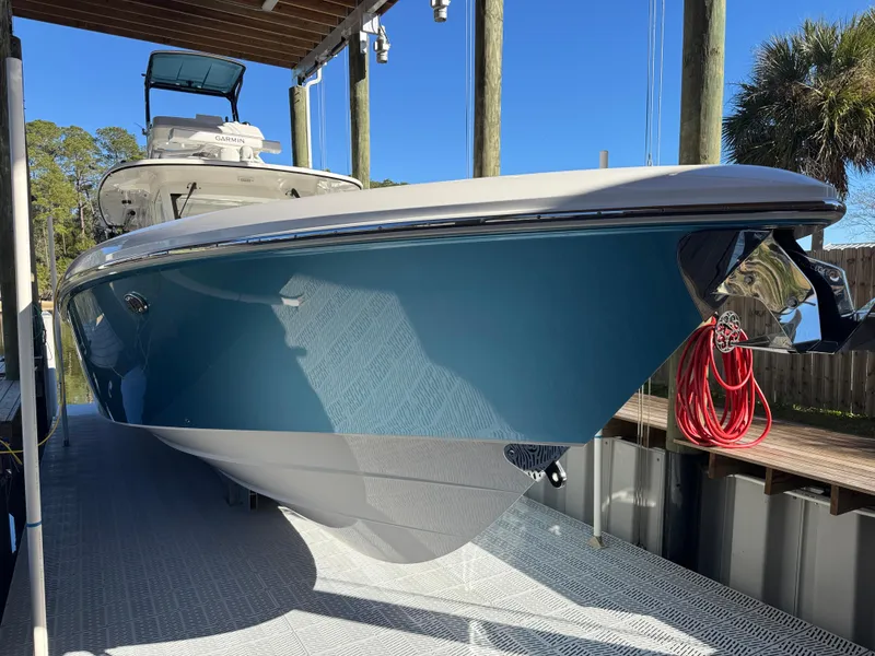 Slide: The Image of 2016 Everglades 435 Center Console boat docked, featuring sleek blue hull design. - 16