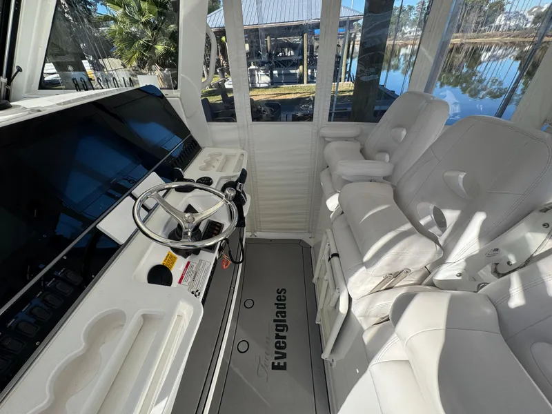 Slide: The Image of Interior of 2016 Everglades 435 Center Console boat with white seating and steering wheel. - 18