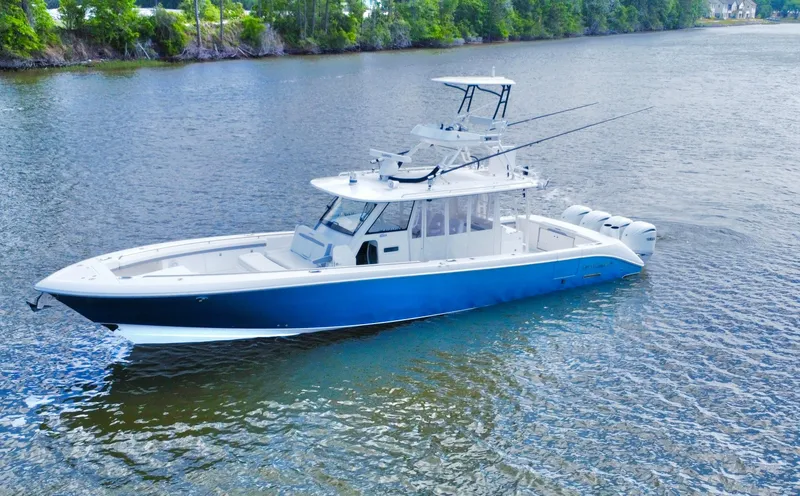 Slide: The Image of 2016 Everglades 435 Center Console boat on calm water, surrounded by trees. - 3