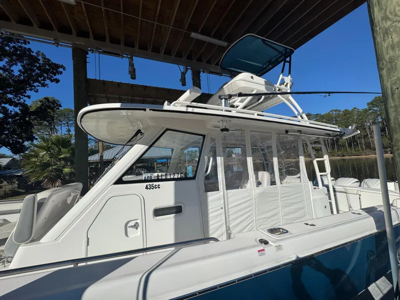 Slide: The Image of 2016 Everglades 435 Center Console boat docked under a wooden canopy. - 31