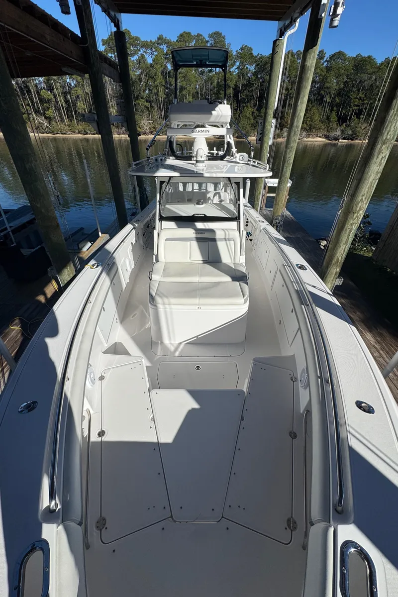 Slide: The Image of 2016 Everglades 435 Center Console boat docked in a serene waterfront setting. - 34