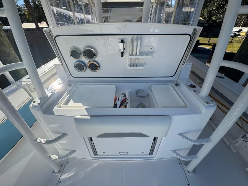 Slide: The Image of 2016 Everglades 435 Center Console boat with open storage compartment and gauges. - 37