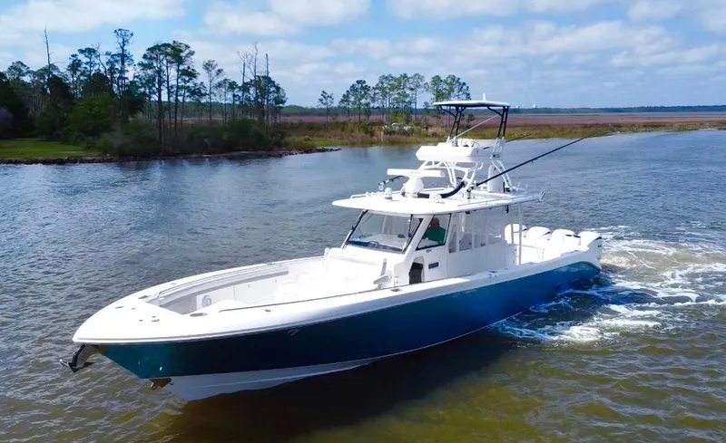 Slide: The Image of 2016 Everglades 435 Center Console boat cruising on a scenic waterway. - 5