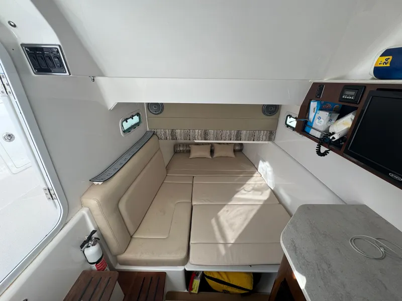 Slide: The Image of Interior cabin of 2016 Everglades 435 Center Console with beige seating and modern amenities. - 58