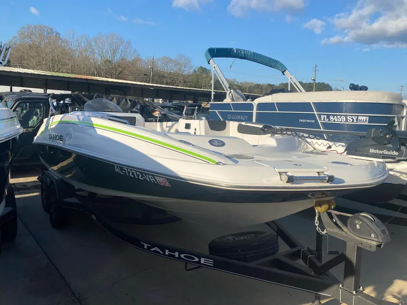 Slide: The Image of 2022 Tahoe 2150 boat on trailer, parked outdoors under a clear sky. - 1