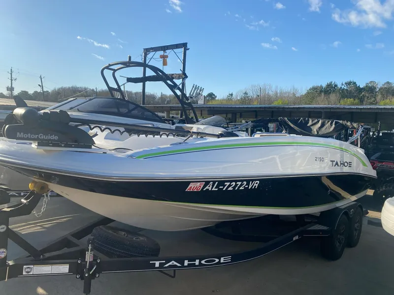 Slide: The Image of 2022 Tahoe 2150 boat on trailer, featuring sleek design and MotorGuide motor. - 2
