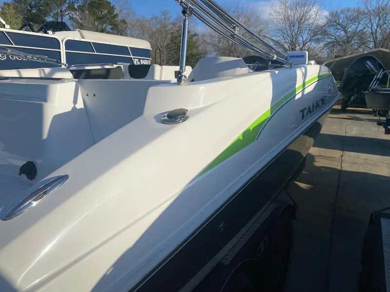 Slide: The Image of 2022 Tahoe 2150 boat with sleek design and green accents, docked outdoors. - 4