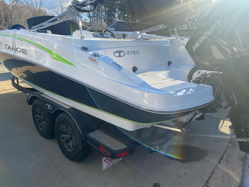 Slide: The Image of 2022 Tahoe 2150 boat on trailer with Mercury engine, parked outdoors. - 5