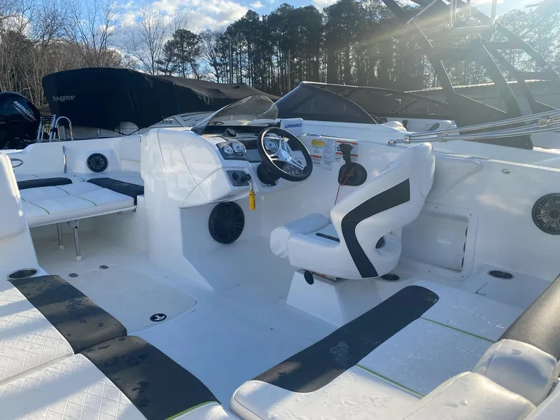 Slide: The Image of 2022 Tahoe 2150 boat interior with seating, steering wheel, and dashboard in a sunny outdoor setting. - 7