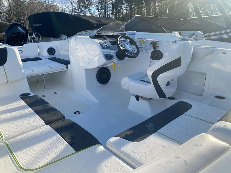 Slide: The Image of 2022 Tahoe 2150 boat interior with seating, steering wheel, and dashboard in sunlight. - 8