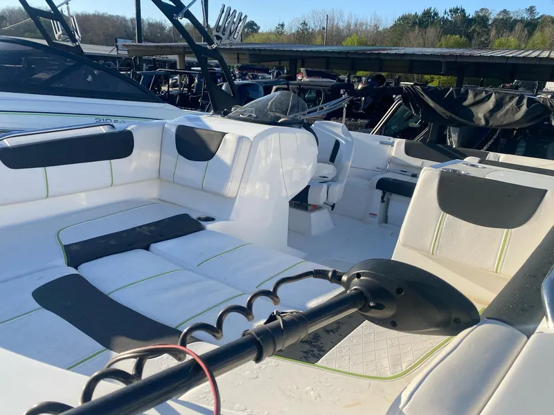 Slide: The Image of 2022 Tahoe 2150 boat interior with white seating and black accents, docked outdoors. - 9