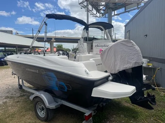 Slide: The Image of 2019 Bayliner Element E16 boat on trailer, parked outdoors under a blue sky. - 4