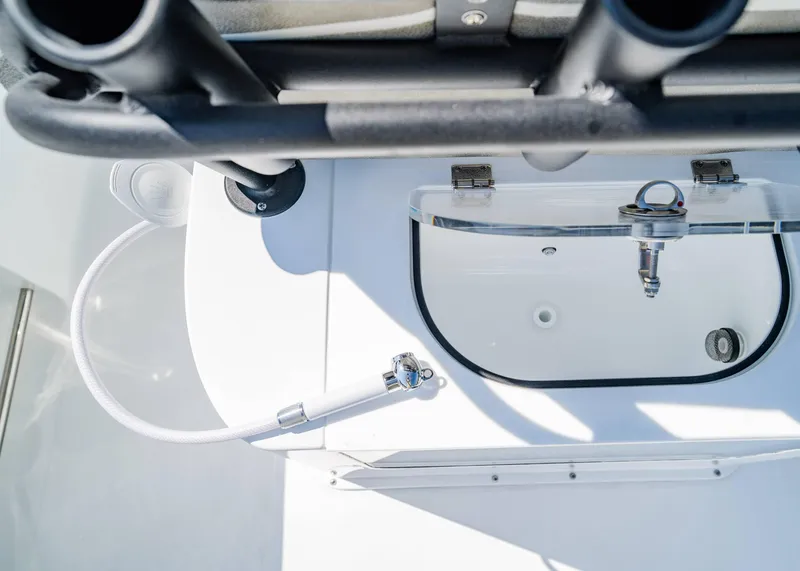 Slide: The Image of 2025 Sea Hunt Gamefish 27 FS boat interior with fishing rod holders and washdown hose. - 11