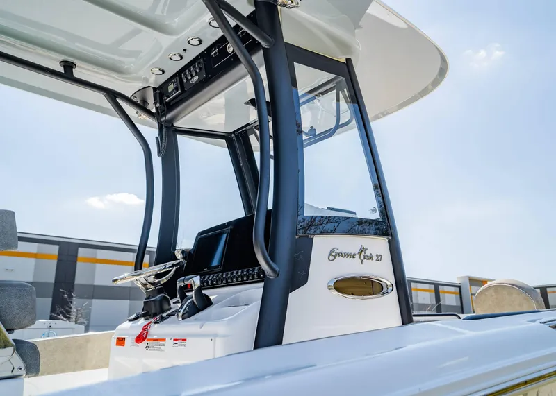 Slide: The Image of 2025 Sea Hunt Gamefish 27 FS boat console with steering wheel and controls. - 12