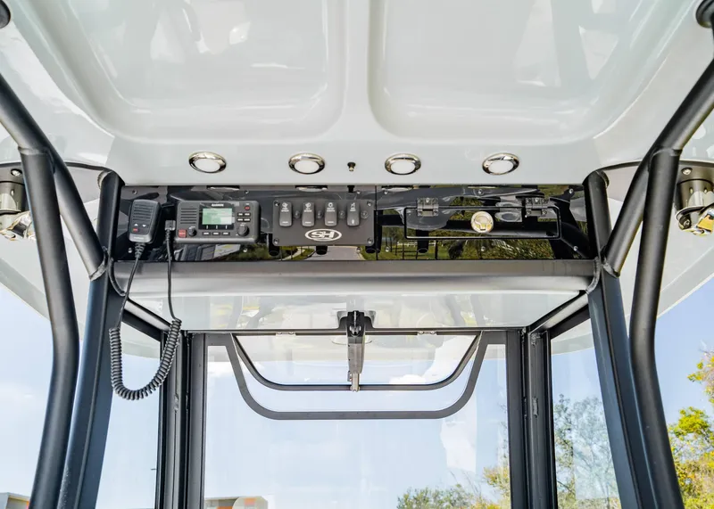 Slide: The Image of 2025 Sea Hunt Gamefish 27 FS boat console with electronic controls and communication devices. - 15