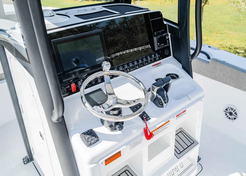 Slide: The Image of 2025 Sea Hunt Gamefish 27 FS boat console with steering wheel and navigation controls. - 16