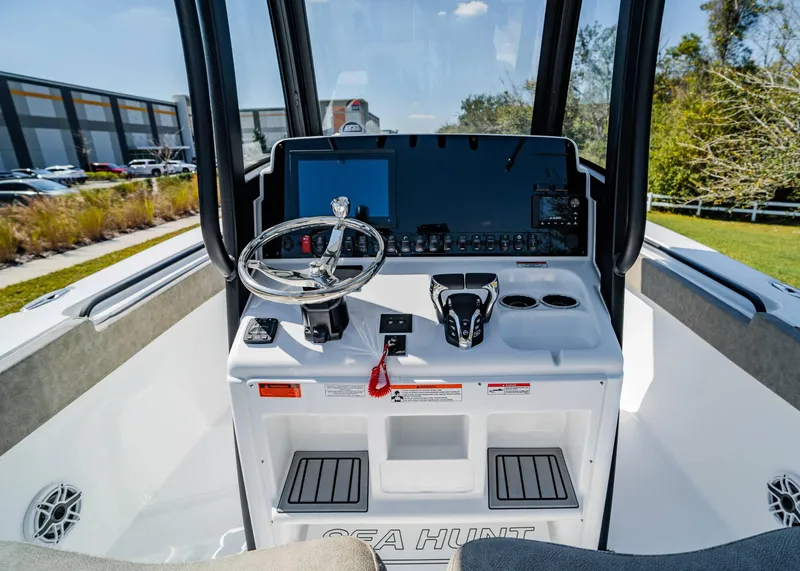 Slide: The Image of 2025 Sea Hunt Gamefish 27 FS boat console with steering wheel and controls. - 17