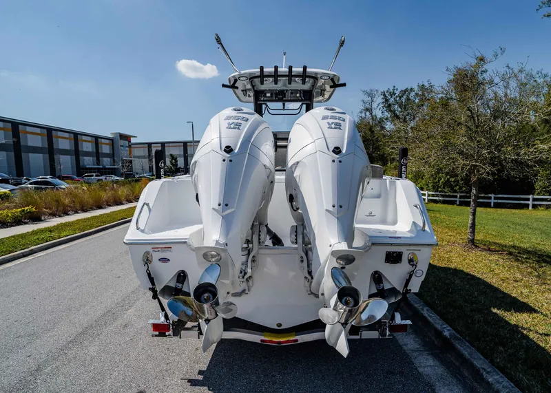 Slide: The Image of 2025 Sea Hunt Gamefish 27 FS with dual outboard engines, parked outdoors. - 4