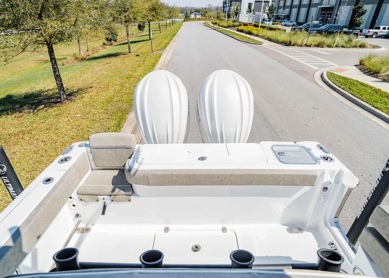 Slide: The Image of 2025 Sea Hunt Gamefish 27 FS boat with dual engines, parked on a sunny street. - 6