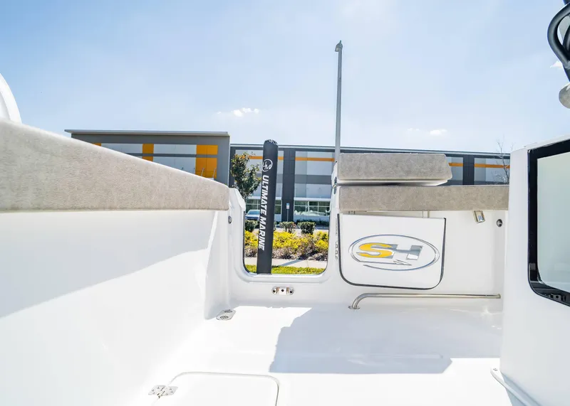 Slide: The Image of 2025 Sea Hunt Gamefish 27 FS boat interior with seating and logo, sunny day. - 8