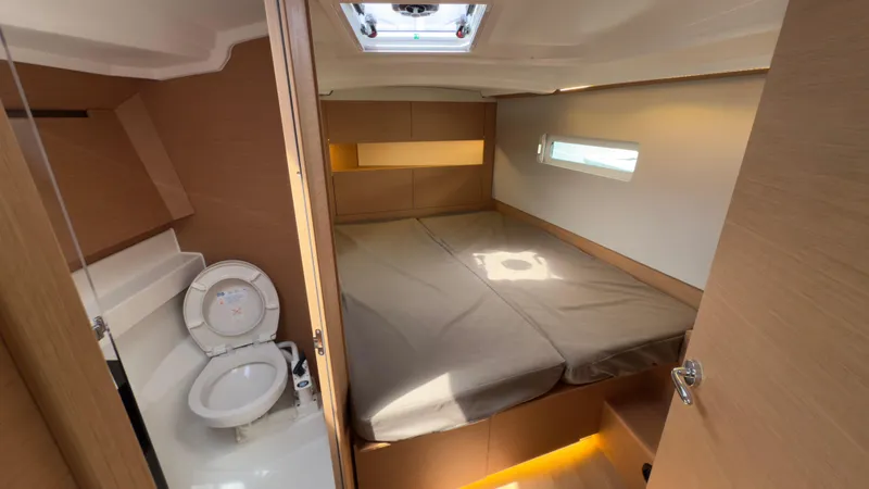 Slide: The Image of 2022 Jeanneau Sun Odyssey 410 cabin interior with bed and compact bathroom. - 10