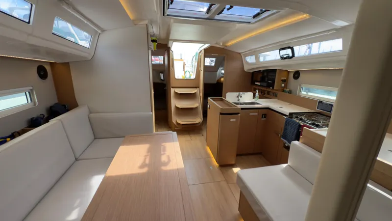 Slide: The Image of Interior of 2022 Jeanneau Sun Odyssey 410 yacht, featuring modern kitchen and seating area. - 13