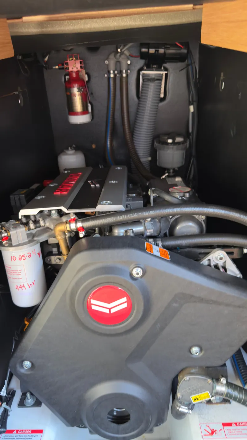 Slide: The Image of Engine compartment of 2022 Jeanneau Sun Odyssey 410 sailboat, featuring modern components and fire extinguisher. - 15
