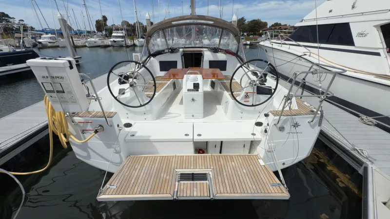 Slide: The Image of 2022 Jeanneau Sun Odyssey 410 docked, featuring dual steering wheels and spacious deck. - 17