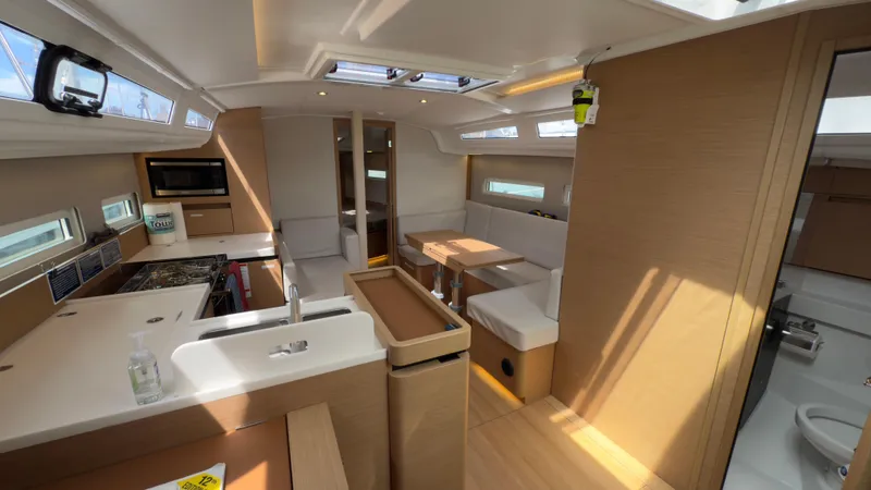 Slide: The Image of Interior of 2022 Jeanneau Sun Odyssey 410 yacht, featuring modern kitchen and dining area. - 5