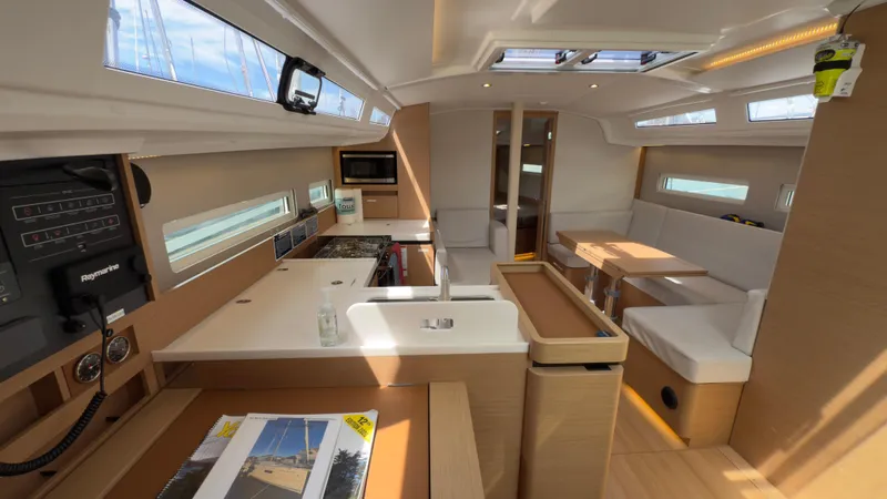 Slide: The Image of Modern interior of 2022 Jeanneau Sun Odyssey 410 sailboat, featuring kitchen and seating area. - 6