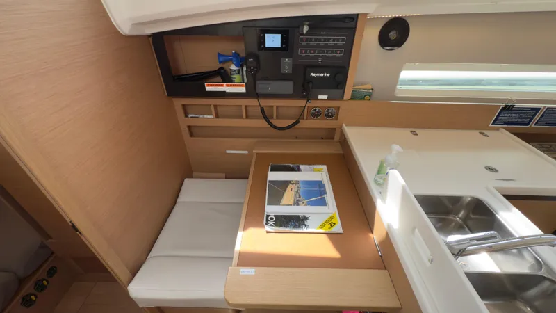 Slide: The Image of Interior of 2022 Jeanneau Sun Odyssey 410 yacht, featuring a compact dining area and control panel. - 7