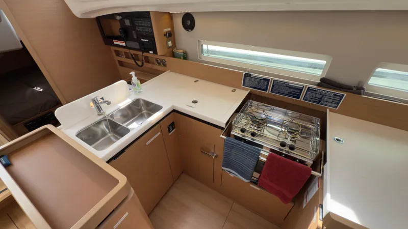 Slide: The Image of Modern kitchen in 2022 Jeanneau Sun Odyssey 410 yacht with dual sinks and stove. - 8