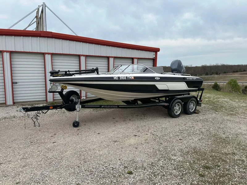 Slide: The Image of 2009 Skeeter SL 190 boat on trailer, parked near storage units. - 0