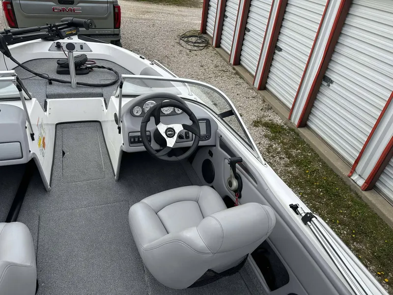 Slide: The Image of 2009 Skeeter SL 190 boat interior with steering wheel and seating, parked near storage units. - 11