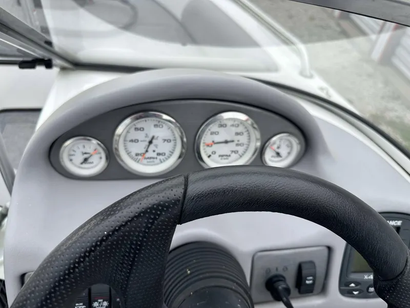 Slide: The Image of Dashboard of a 2009 Skeeter SL 190 boat with gauges and steering wheel. - 17