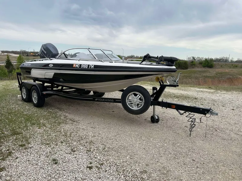 Slide: The Image of 2009 Skeeter SL 190 boat on trailer, parked on gravel, under cloudy sky. - 19