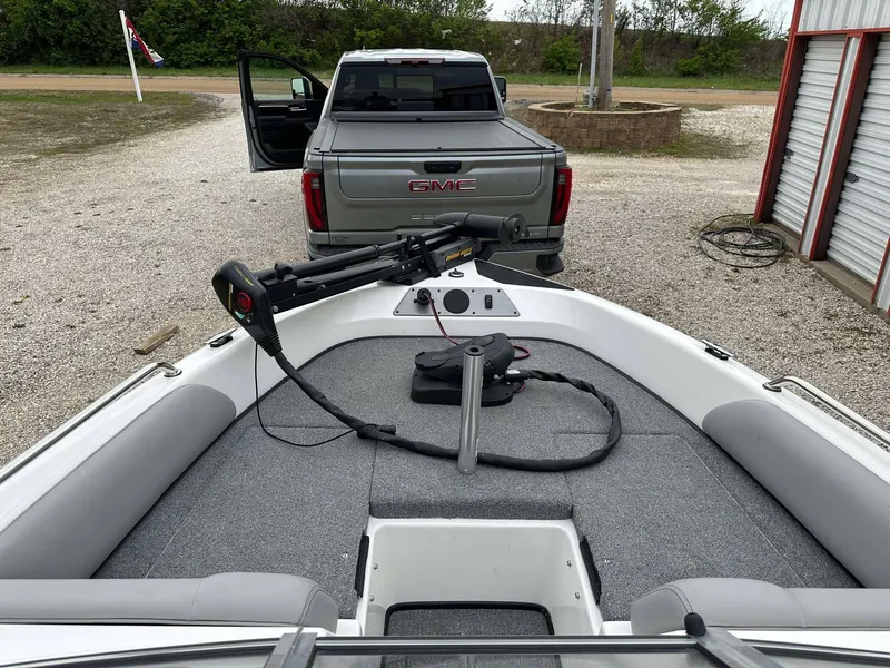 Slide: The Image of 2009 Skeeter SL 190 boat with trolling motor, parked near a GMC truck. - 27