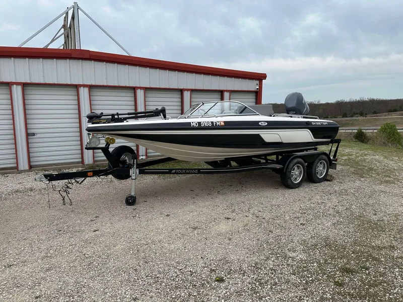 Slide: The Image of 2009 Skeeter SL 190 boat on trailer, parked near storage units. - 28